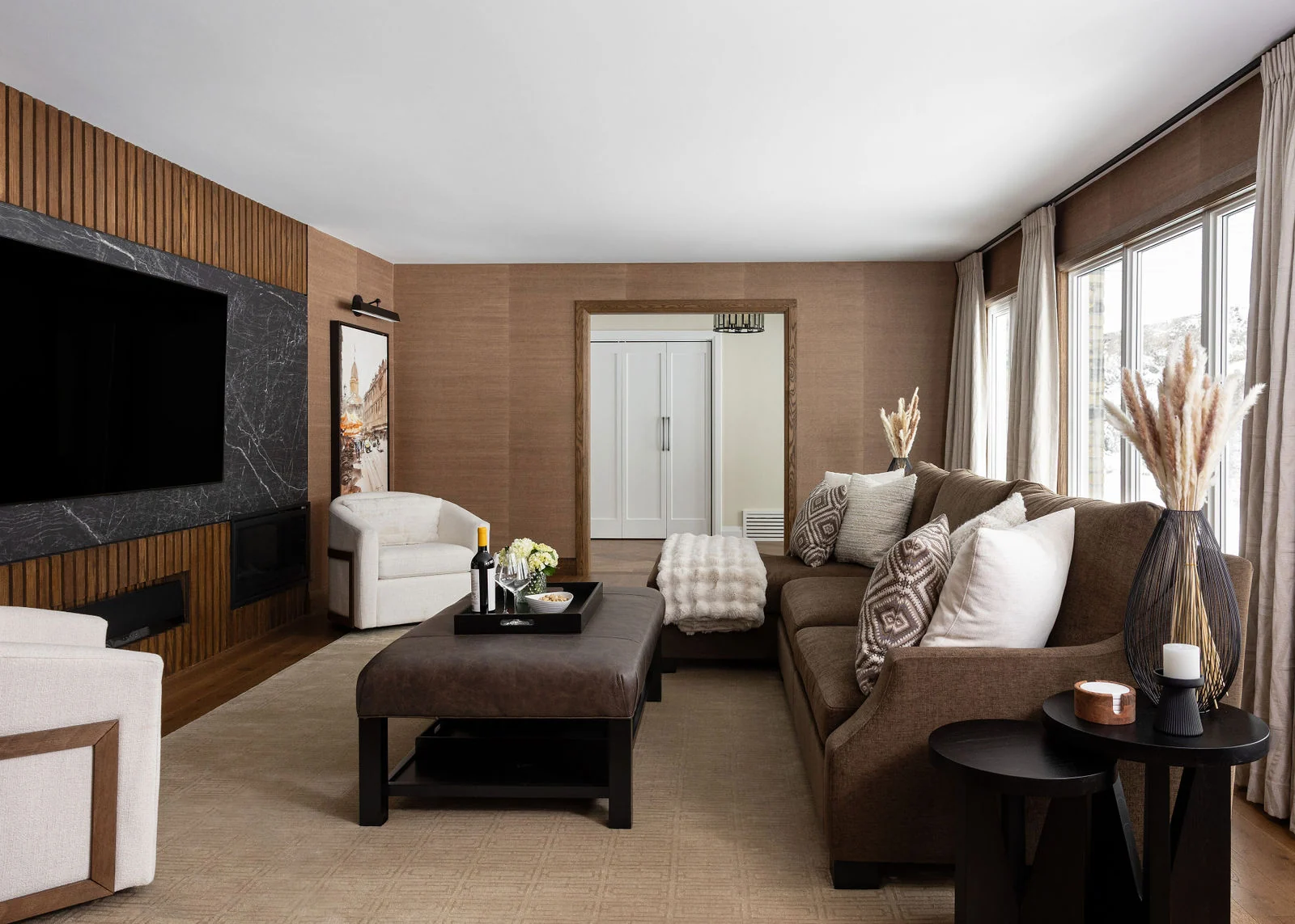 A wood-panelled room with a stone fireplace and built-in shelving