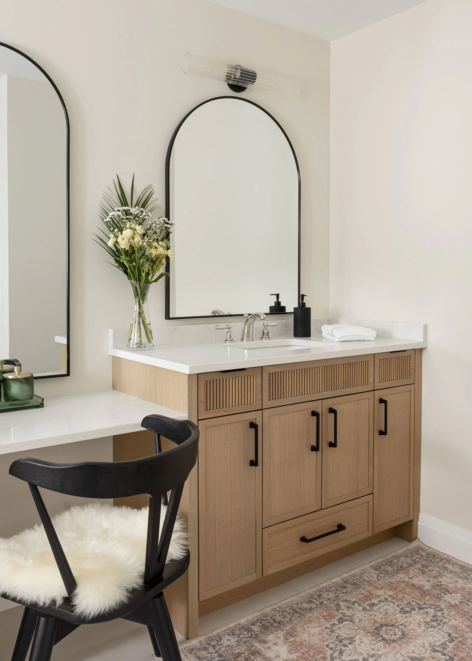 Oak bathroom cabinetry with an arched mirror