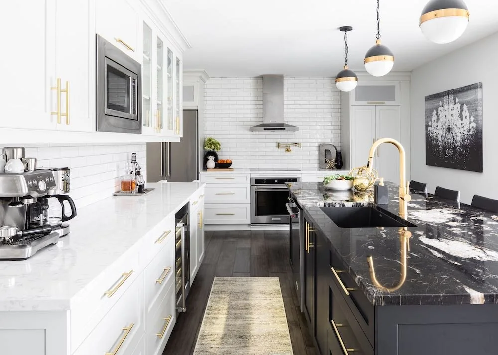 Kitchen island with a dark patterned counter and brass-coloured faucet at Devlin I