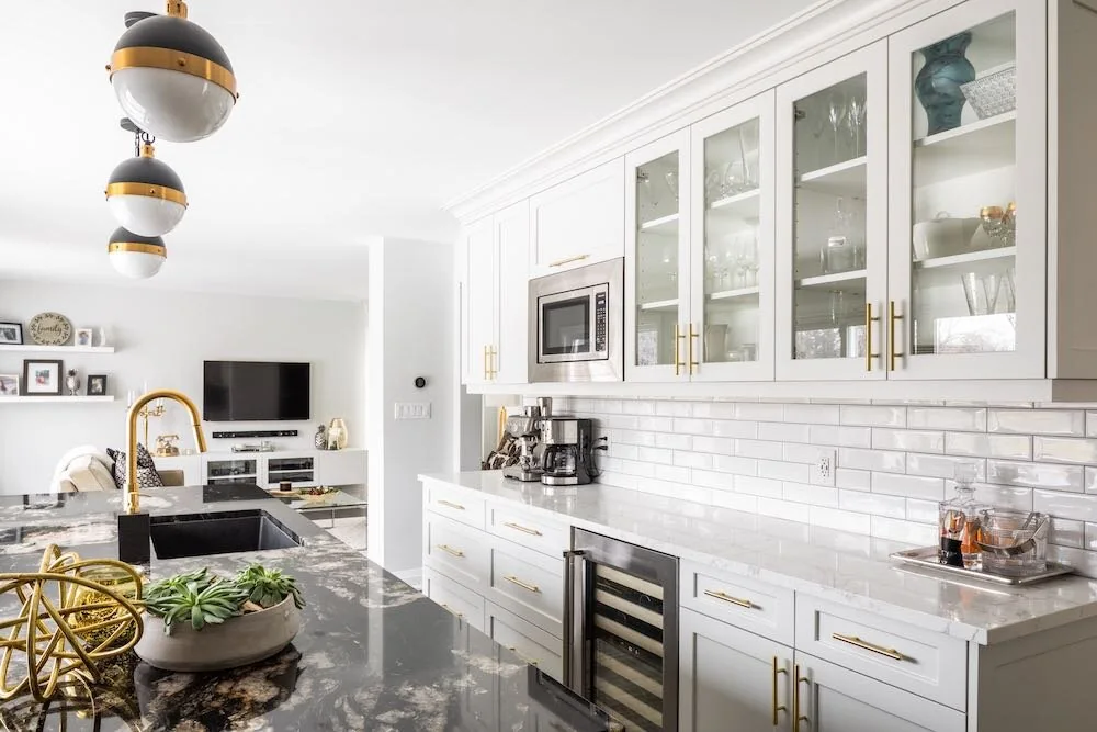 Glass-front kitchen cabinets above a white tile backsplash at Devlin I