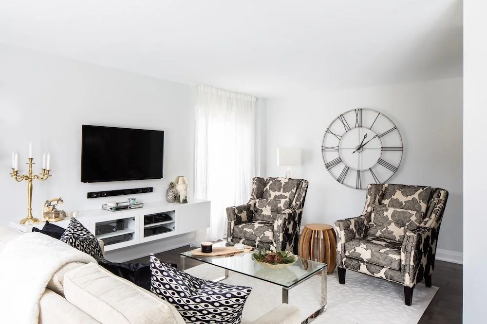 Living room with patterned armchairs, a glass coffee table and a television at Devlin I