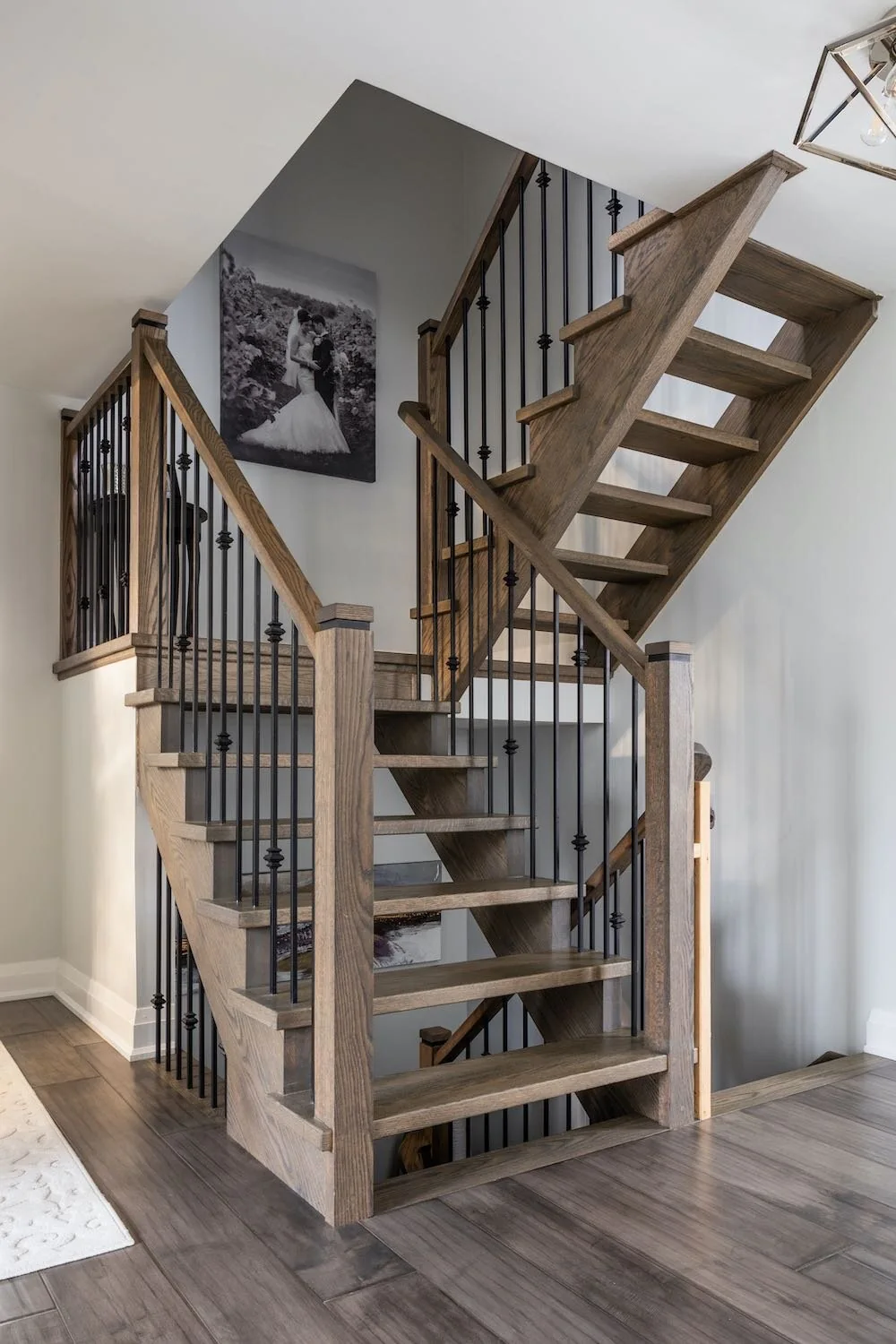 Wood staircase with dark metal balusters at Devlin I