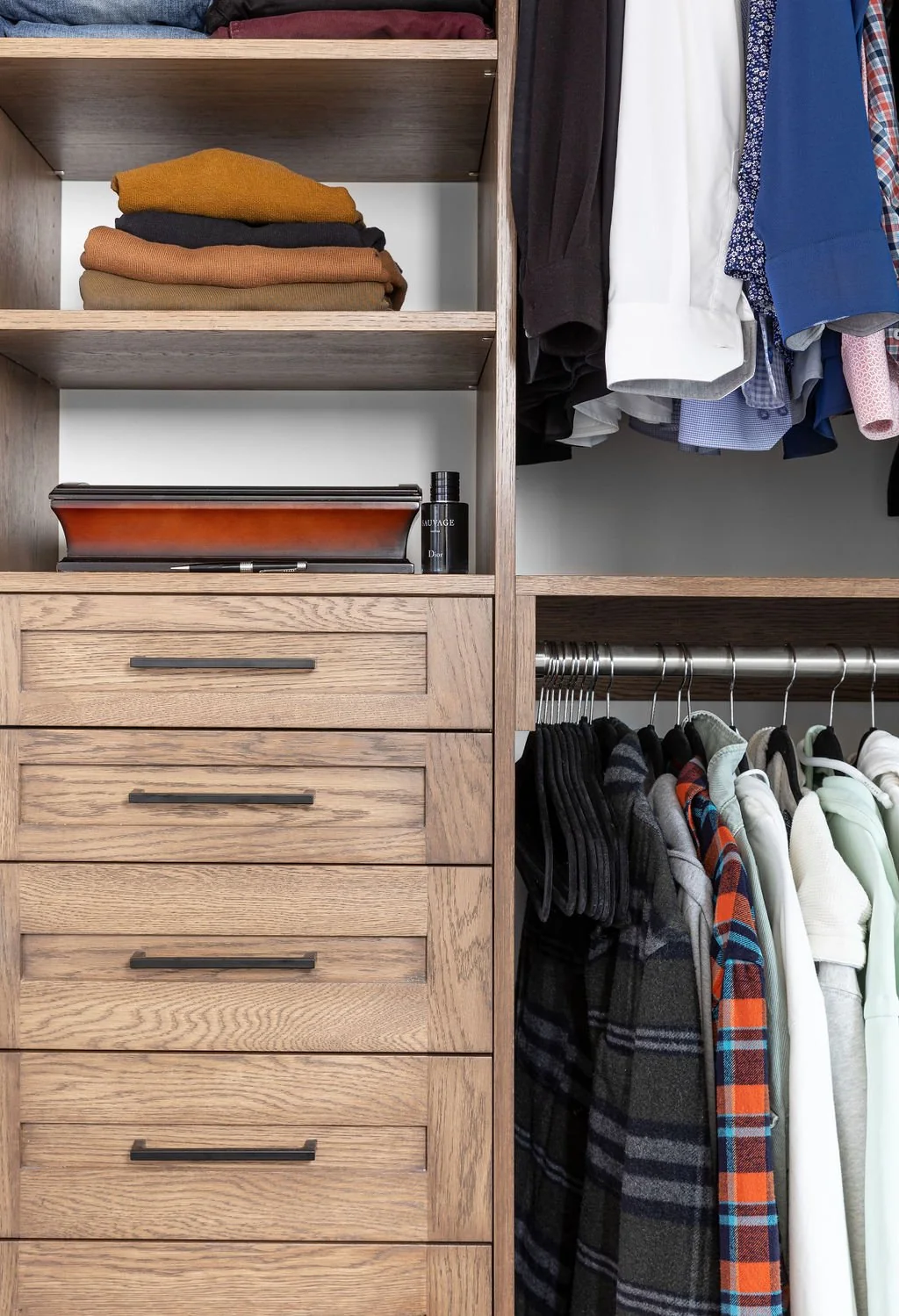 Wood drawers and open clothing storage in the dressing room at Devlin II