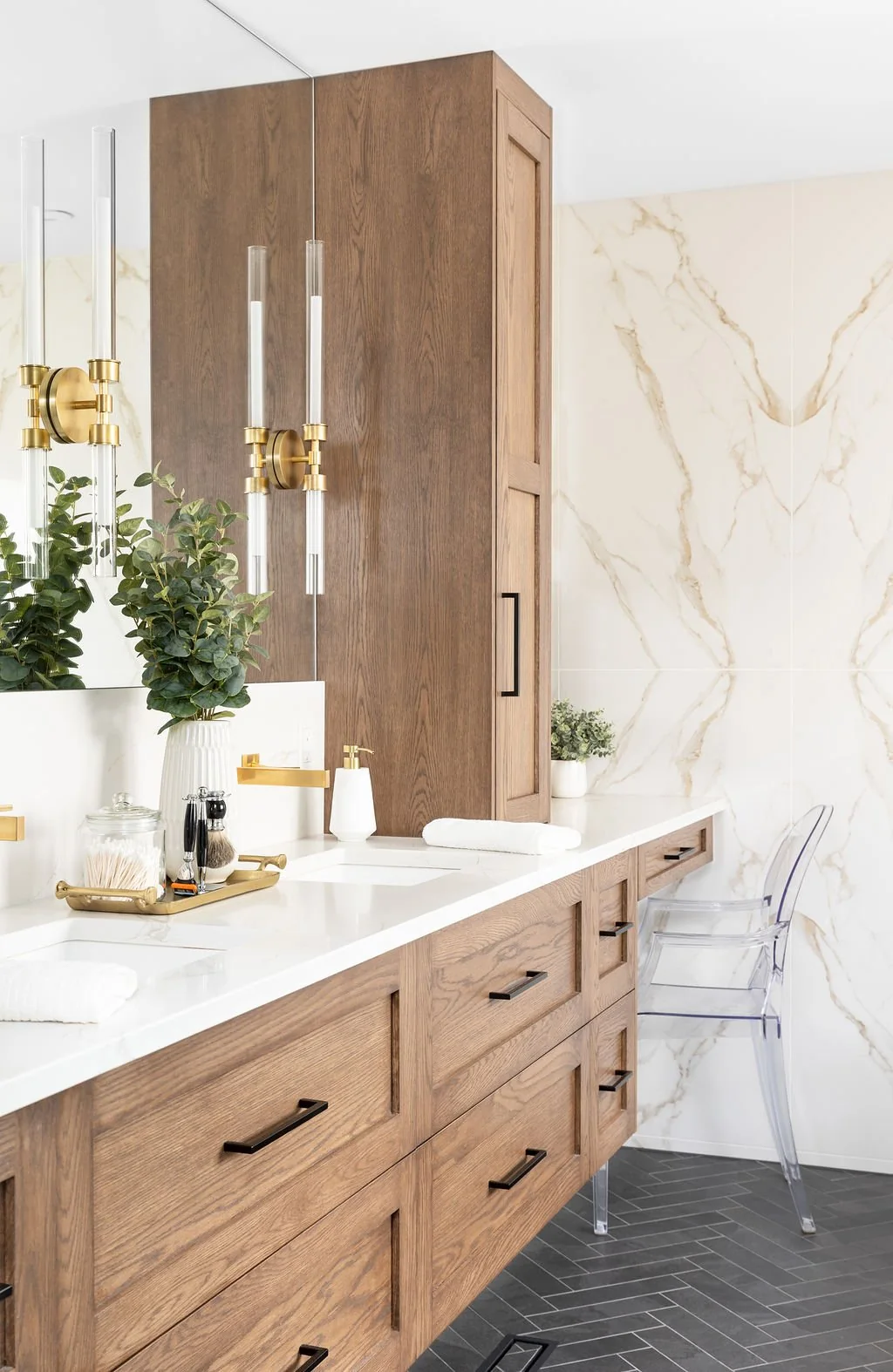 Bathroom vanity with wood cabinetry and wall-mounted brass-coloured lights at Devlin II