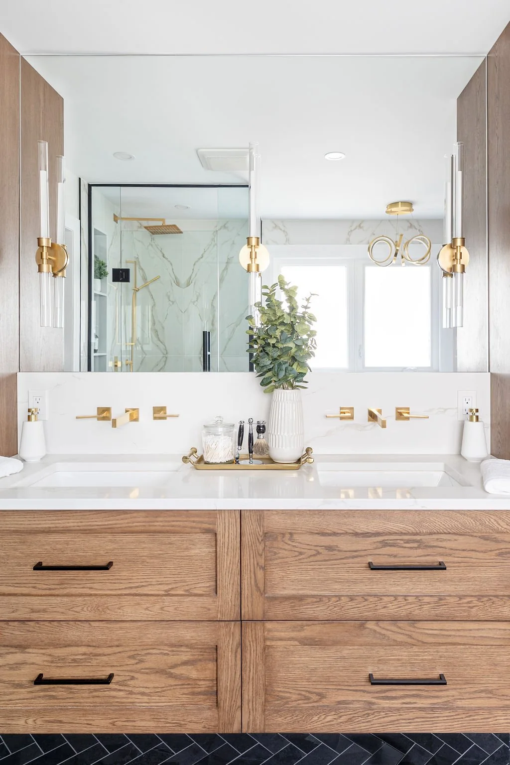 Wide bathroom mirror above a wood double vanity at Devlin II