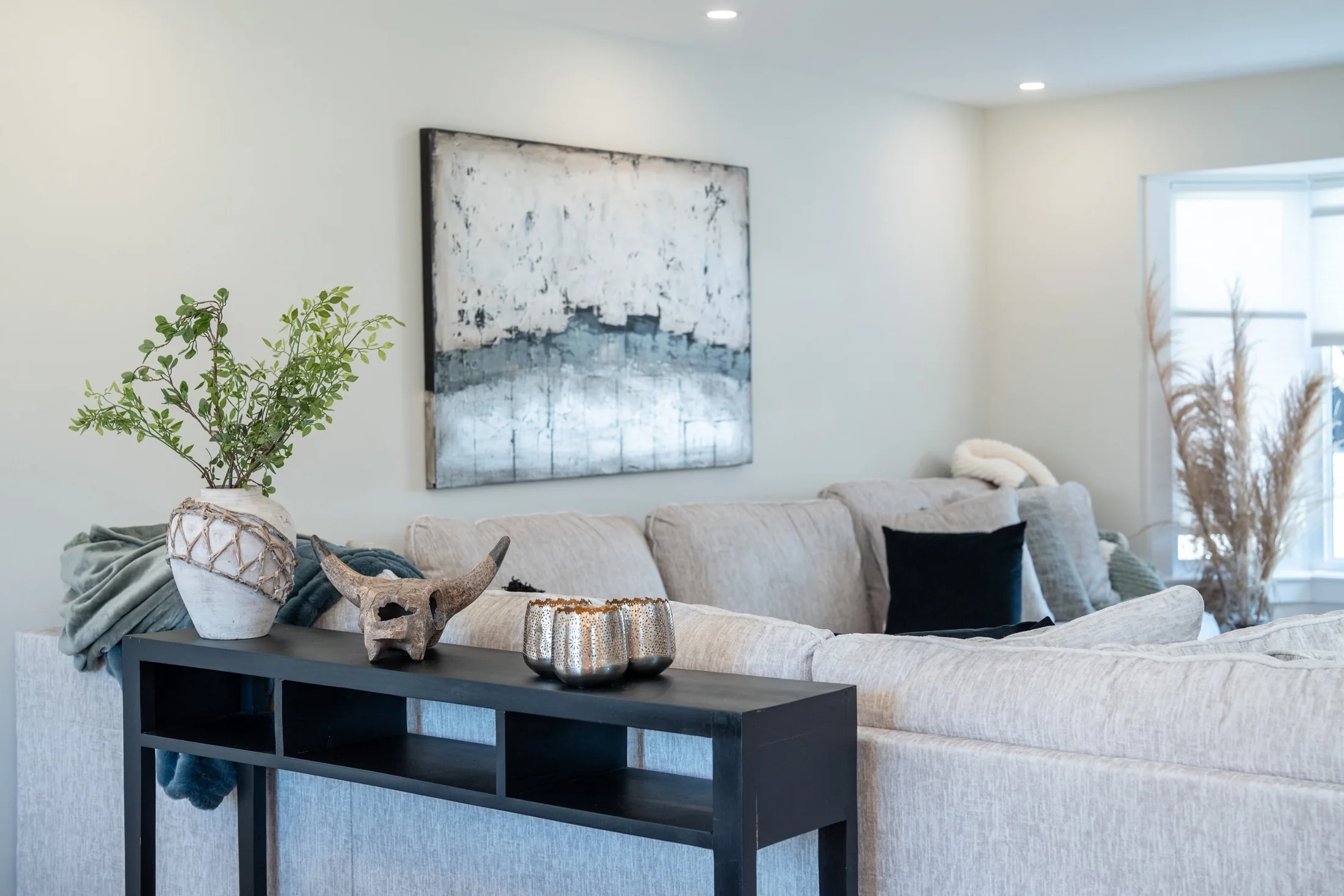 Living room with a pale sectional sofa and artwork at Joseph I