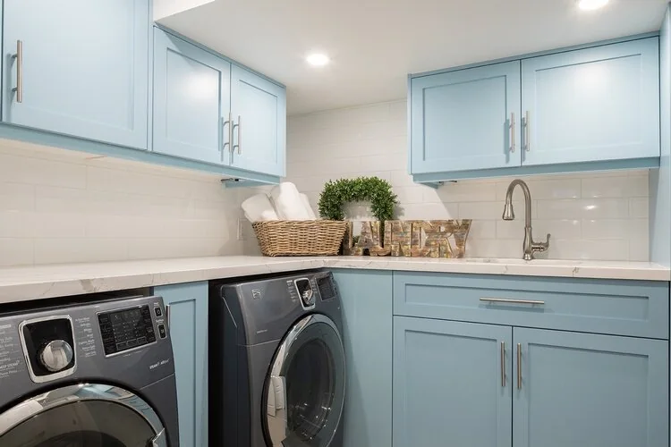 Laundry room with blue cabinetry, a sink and front-loading machines at Kingsridge I