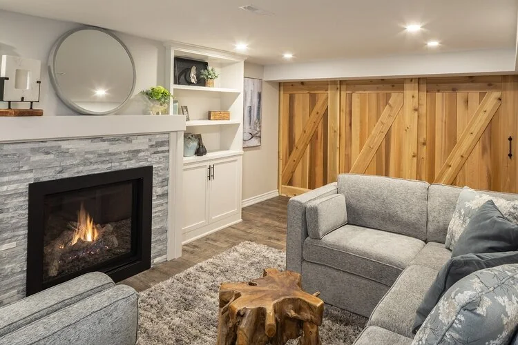 Basement sitting room with a fireplace, built-in shelves and wood sliding doors at Kingsridge I