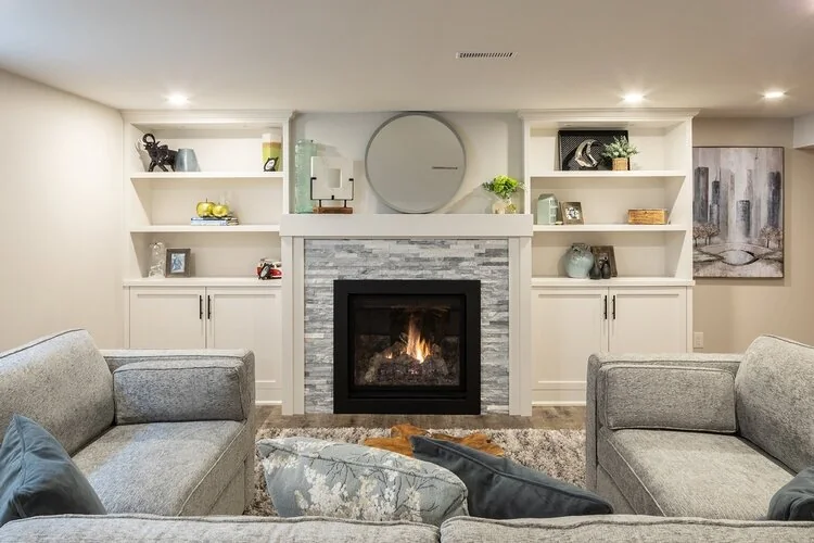 Fireplace between white cabinets and open shelves in a basement sitting room at Kingsridge I