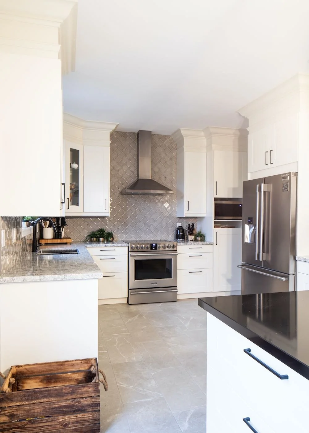 View through the kitchen with white cabinetry and a dark counter at Mariposa I