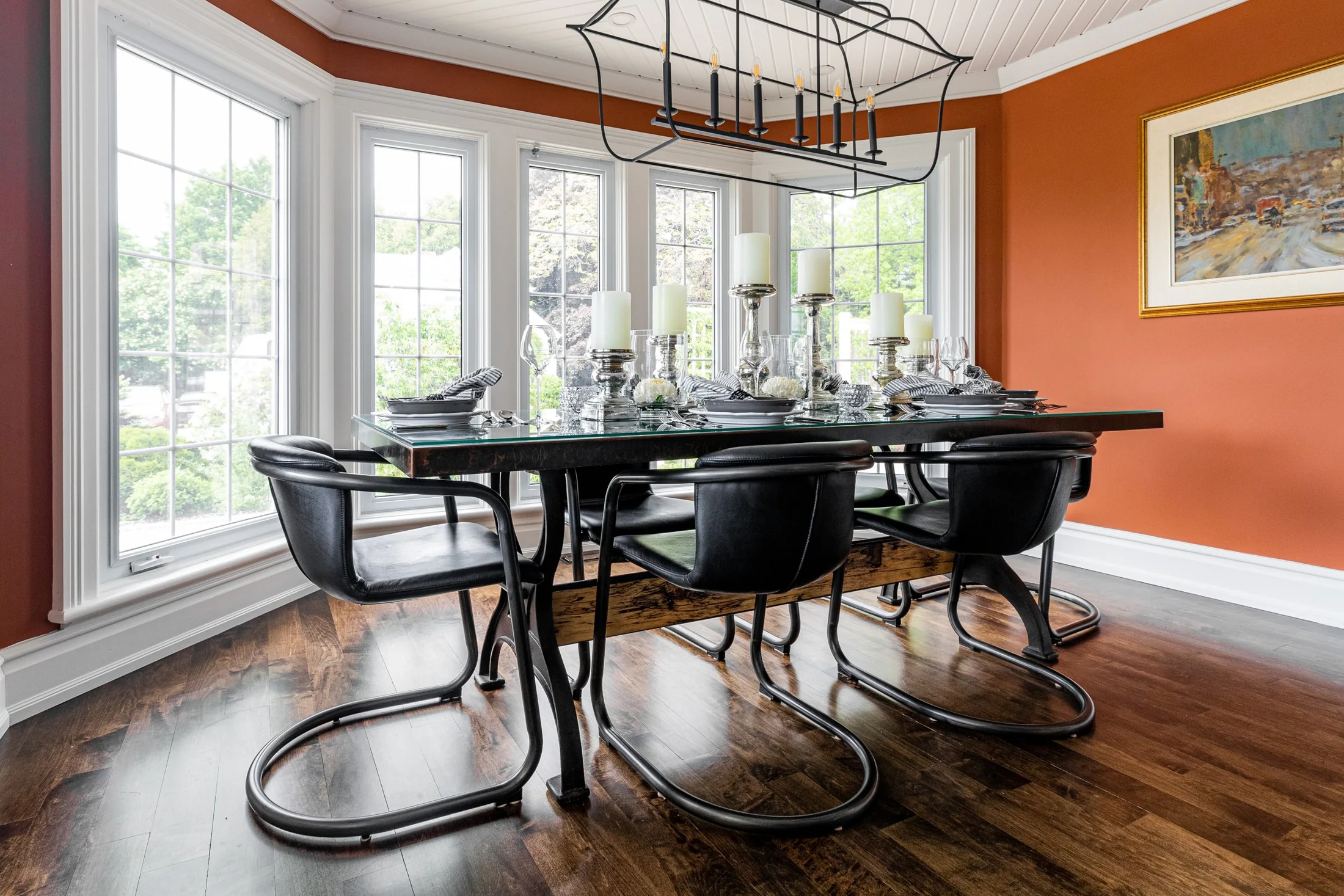 Dining area with black chairs beside a curved wall of windows at South Rankin I
