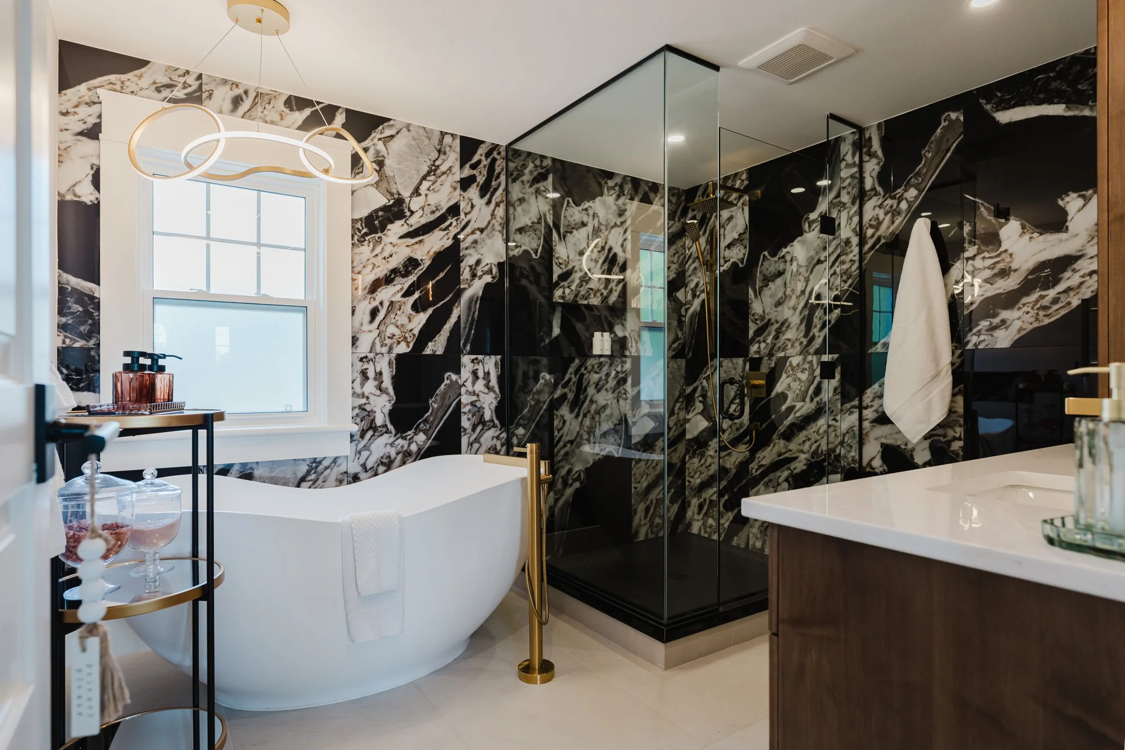 Bathroom with a freestanding tub, glass shower and dark patterned wall surfaces at South Rankin II